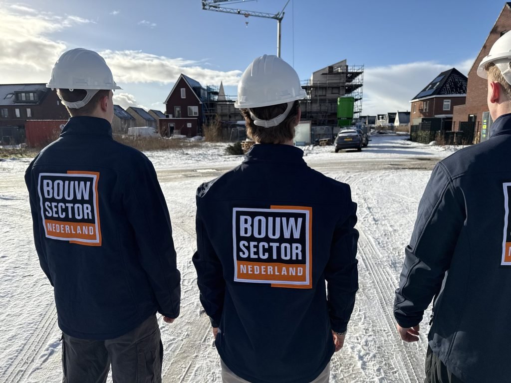 Vakmensen van Bouwsector Nederland met witte helm op een winterse bouwweg tussen nieuwe woningen